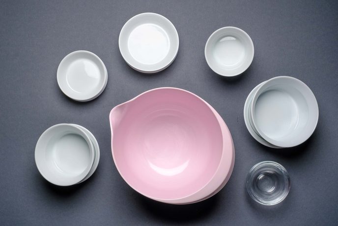 Weiße Porzellanschälchen, eine kleine Glasschale und eine rosa Rührschüssel aus Kunststoff