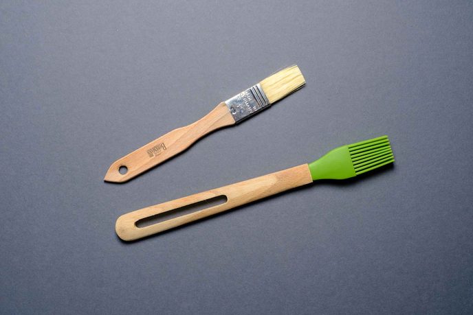 Backpinsel mit Naturborsten und Holzgriff neben einem Silikonpinsel
