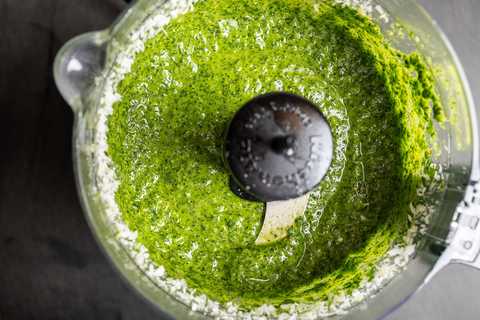 Fertiges grünes Bärlauchpesto im Behälter des Universalzerkleinerers