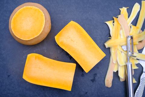 Geschälter Butternut-Kürbis, Kürbisschalen und ein Pendelschäler