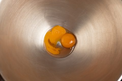 Zwei Eigelbe in einer großen Rührschüssel aus Edelstahl