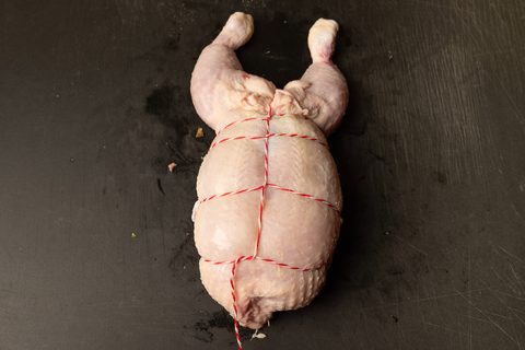 Gefüllte Hähnchenroulade mit rot-weißem Küchengarn gebunden