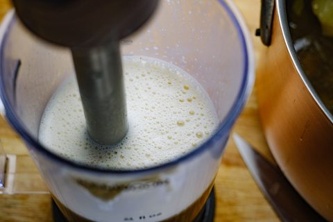 Stabmixer in einem hohen Becher mit heller Soße