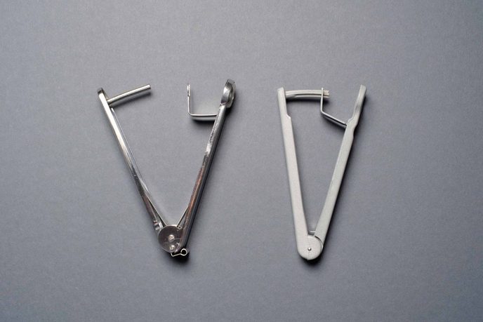 Zwei Kirschentkerner mit Zangengriff aus Metall und hellem Kunststoff