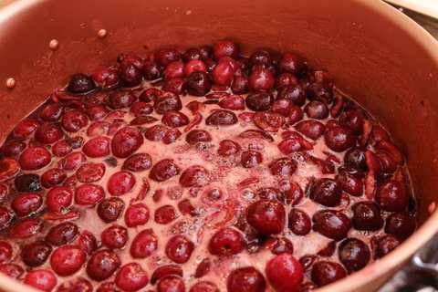 Kochende Kirschmarmelade im Kupfertopf
