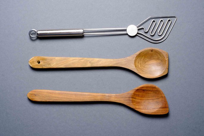 Zwei Kochlöffel aus Holz und ein Kartoffelstampfer aus Edelstahl