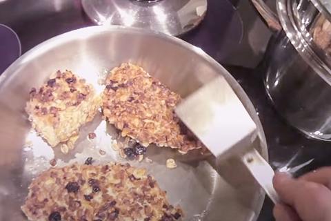 Paniertes Schnitzel wird in der Edelstahlpfanne mit einem Pfannenwender gewendet