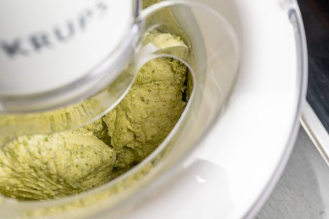 Hellgrüne Eismasse wird in der Eismaschine gerührt und gefroren