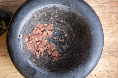 Sardellen und Knoblauch im Steinmörser zerstoßen