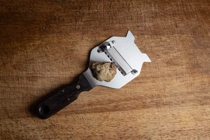Weißer Trüffel auf einem Trüffelhobel mit Holzgriff